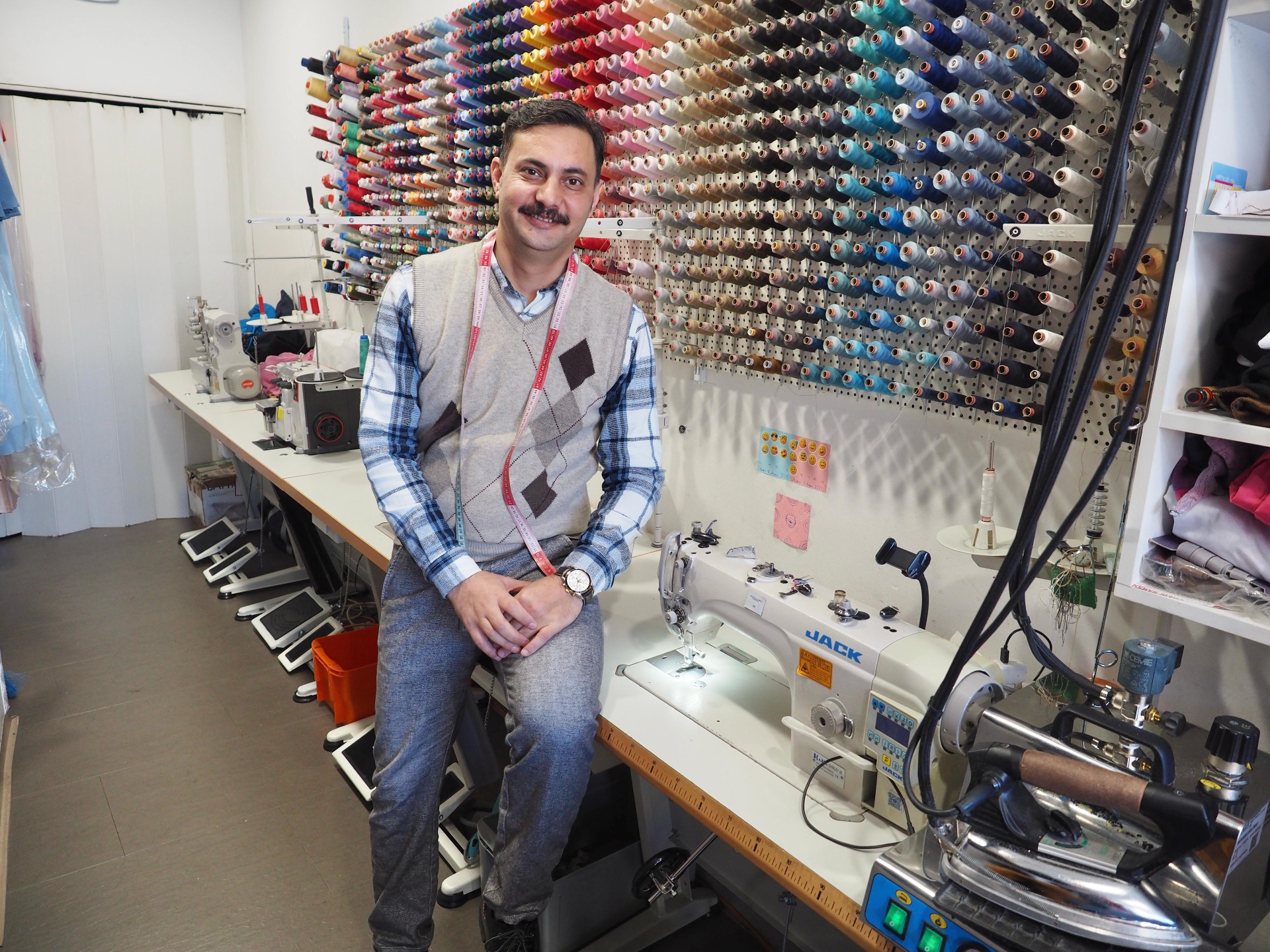 Haram in seinem Atelier vor der Garnwand